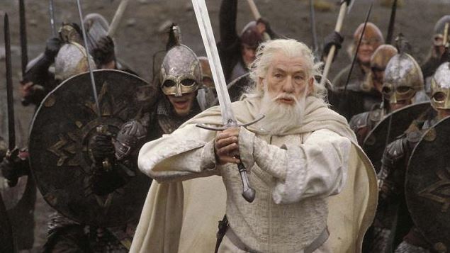 A still from The Return of the King featuring Gandalf charging into a fight, sword readied.